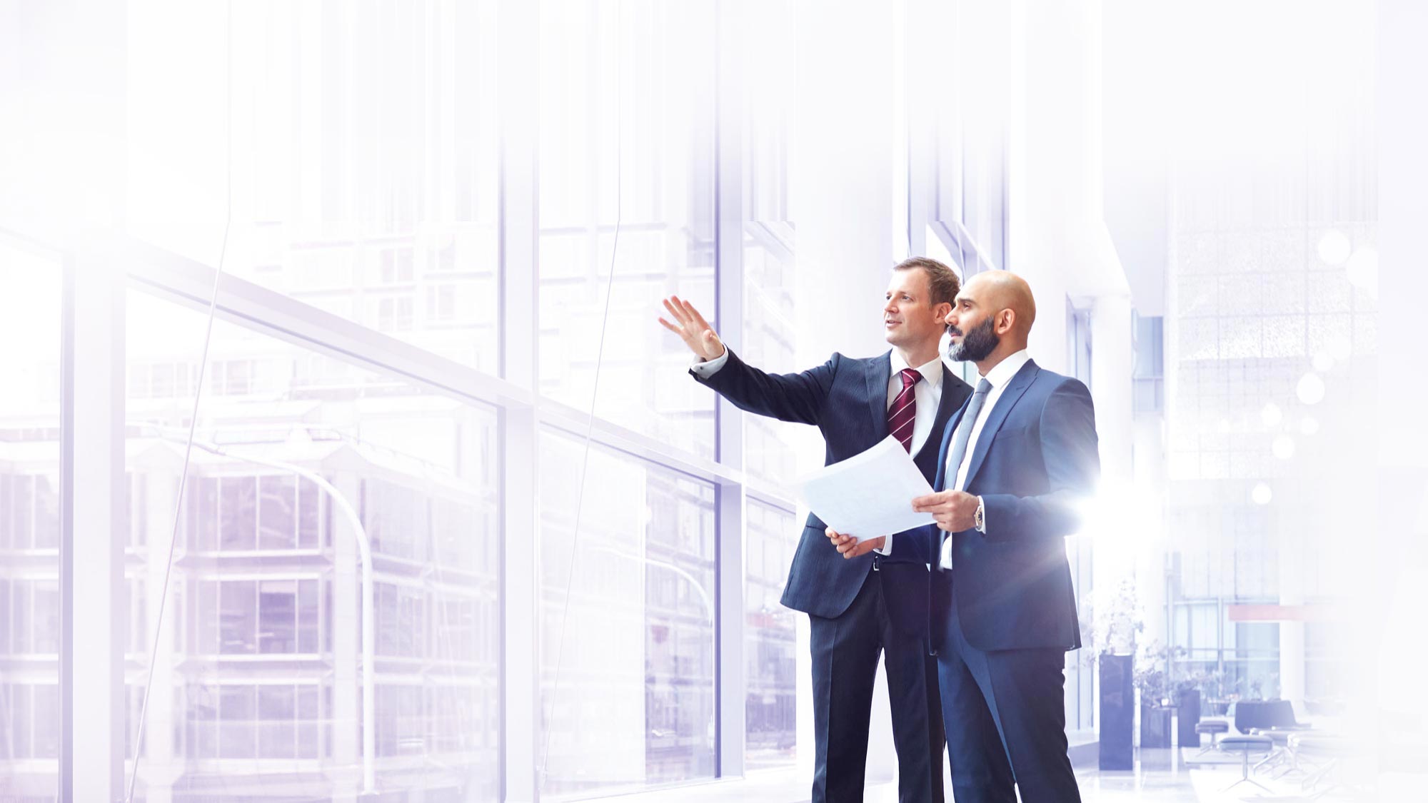 two professionals having a discussion in front of a large window